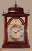 Richly coloured mahogany bell top case with caryatids to front door corners, cast rococo feet, side handles, flambeau finials and side frets. Finely pierced top cresting.